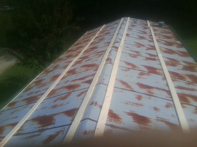 Rusted metal roof panels with new wood purlins before replacement — Storm Damage Roof Repair in Riddleton by Roofing Brothers
