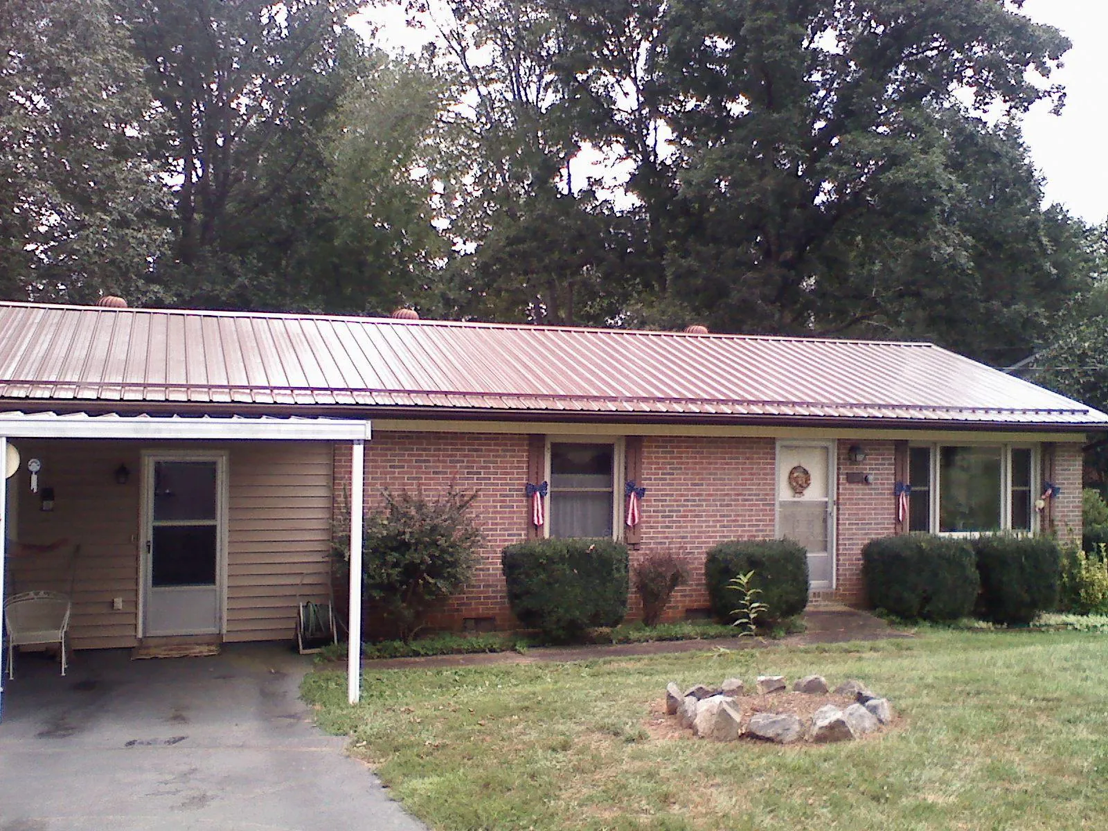 Bronze metal roof and carport on a brick ranch home — Roof Repair work by our crew in Riddleton